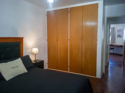 a bedroom with a bed and wooden cabinets at Laprida y Trejo Apartamento in Cordoba