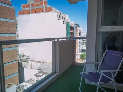 a purple chair sitting on a balcony with a window at Laprida y Trejo Apartamento in Cordoba