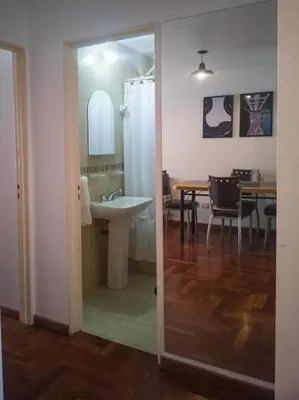 a bathroom with a sink and a dining room with a table at Laprida y Trejo Apartamento in Cordoba