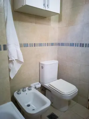 a bathroom with a white toilet and a sink at Laprida y Trejo Apartamento in Cordoba