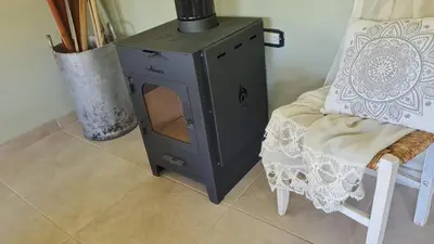 a stove sitting next to a chair next to a table at Las Brisas casas de campo un lugar para soñar in San Antonio de Arredondo