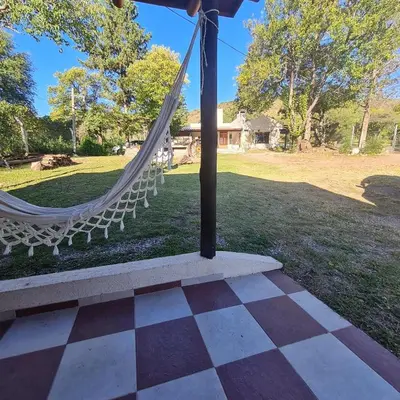 a hammock in a park with a field and a house at Las Brisas casas de campo un lugar para soñar in San Antonio de Arredondo