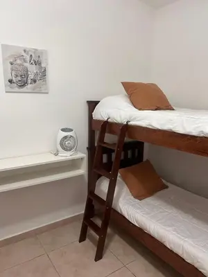 a room with two bunk beds and a ladder at FRAMA Cabañas del Lago in Potrero de Garay