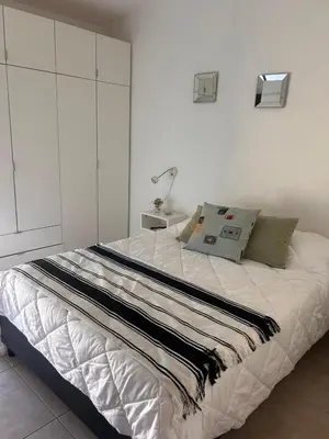 a bed in a bedroom with a white wall at FRAMA Cabañas del Lago in Potrero de Garay