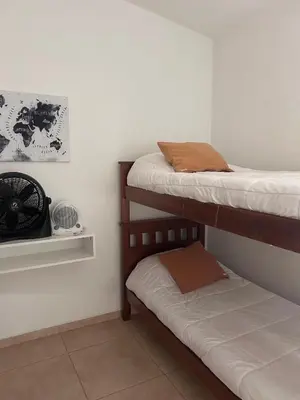 a room with two bunk beds and a small niche with a sqor at FRAMA Cabañas del Lago in Potrero de Garay