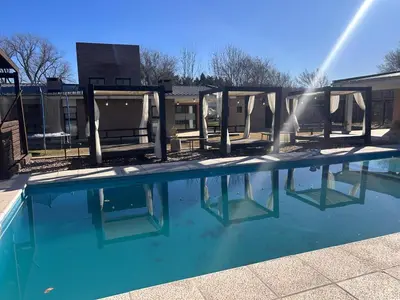 a swimming pool with blue water in front of a building at FRAMA Cabañas del Lago in Potrero de Garay