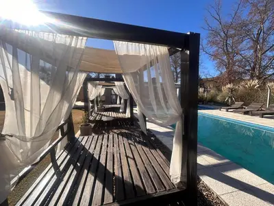 a wooden deck with a canopy next to a pool at FRAMA Cabañas del Lago in Potrero de Garay