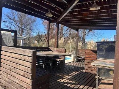 a wooden patio with a table and a grill at FRAMA Cabañas del Lago in Potrero de Garay