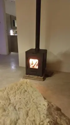 a stove in a room with a rug and a fireplace at I Víla in Villa Carlos Paz