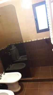 a bathroom with a toilet and a sink and a window at ASM CASA III in Merlo