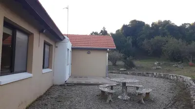 a table and two benches next to a building at ASM CASA III in Merlo