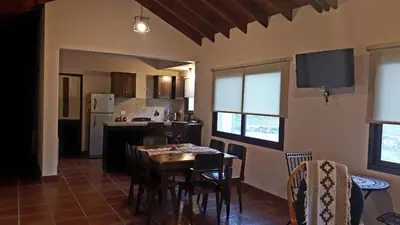 a kitchen and dining room with a table and chairs at ASM CASA III in Merlo