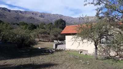a small white building with a mountain in the background at ASM CASA III in Merlo