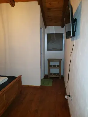 a bedroom with a bed and a television on a wall at Descanso Serrano in Santa Rosa de Calamuchita
