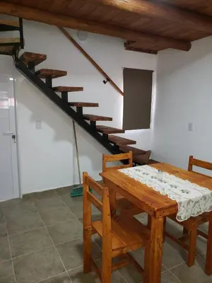 a dining room with a table and a staircase at Descanso Serrano in Santa Rosa de Calamuchita