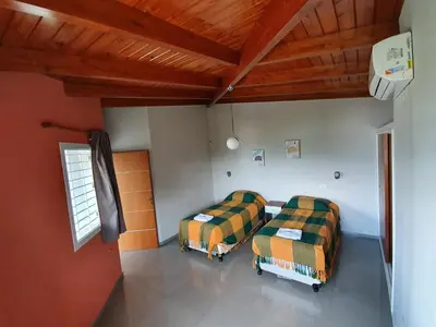 two beds in a room with red walls and wooden ceilings at Balcones del Lago in Villa Parque Siquiman