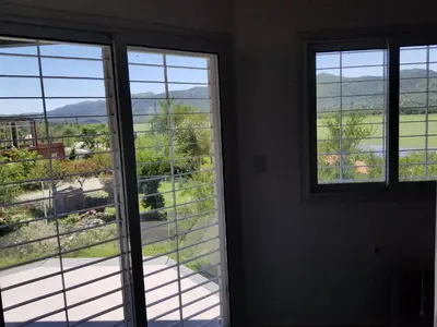 a room with three windows and a view of a yard at Balcones del Lago in Villa Parque Siquiman