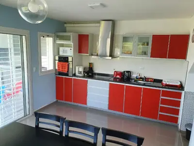 a kitchen with red cabinets and a table and chairs at Balcones del Lago in Villa Parque Siquiman