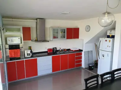 a kitchen with red cabinets and a white refrigerator at Balcones del Lago in Villa Parque Siquiman