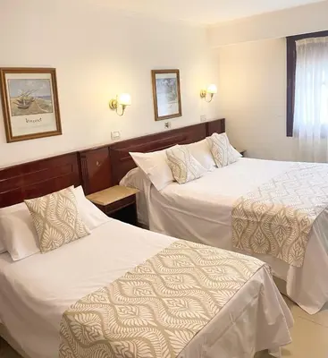 a hotel room with two beds and a window at HOTEL CASTELAR CORDOBA in Cordoba