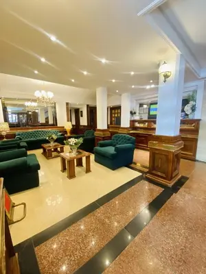 a large living room with green couches and tables at HOTEL CASTELAR CORDOBA in Cordoba
