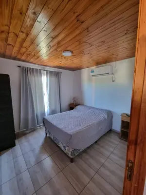 a bedroom with a bed and a wooden ceiling at Terrazas de Estancia in Villa Carlos Paz