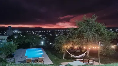 a backyard at night with a pool and lights at Terrazas de Estancia in Villa Carlos Paz