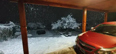 a red car parked in a snow covered yard at Terrazas de Estancia in Villa Carlos Paz