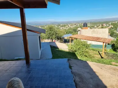a person standing on the porch of a house at Terrazas de Estancia in Villa Carlos Paz