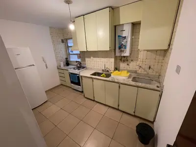 a kitchen with white cabinets and a sink and a refrigerator at Amplio departamento ZONA CENTRO (2) in Cordoba