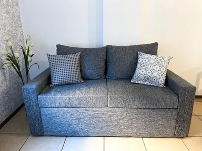 a gray couch with pillows in a living room at Amplio departamento ZONA CENTRO (2) in Cordoba