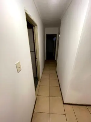 an empty hallway with a white wall and a tile floor at Amplio departamento ZONA CENTRO (2) in Cordoba