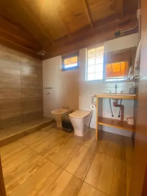 a bathroom with a toilet and a sink at Alma Serrana - Suites de montaña! in La Cumbrecita