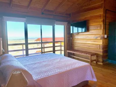 a bedroom with a bed and a view of the ocean at Alma Serrana - Suites de montaña! in La Cumbrecita