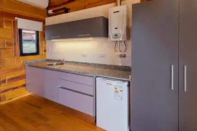 a kitchen with a refrigerator and a counter top at Alma Serrana - Suites de montaña! in La Cumbrecita