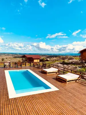 a deck with a swimming pool on top of a house at Alma Serrana - Suites de montaña! in La Cumbrecita