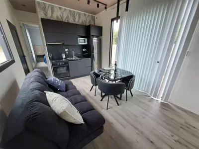 a living room with a couch and a table with chairs at Love Sunset in Villa Carlos Paz