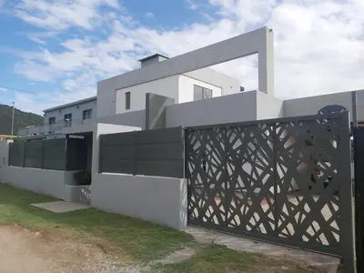 a white house with a gate in front of it at Love Sunset in Villa Carlos Paz