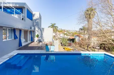 a blue swimming pool in front of a house at LA ARMONIA in Cordoba