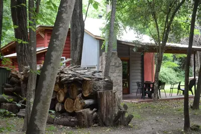 a pile of logs in front of a cabin at Manantial Hostería & Cabañas in Nono