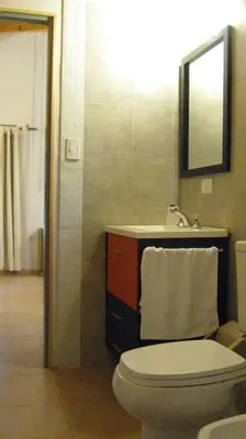 a bathroom with a toilet and a sink and a mirror at Manantial Hostería & Cabañas in Nono