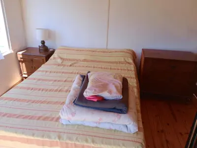 a bed with a pillow sitting on top of it at Cabañas Guayacán in Bialet Massé