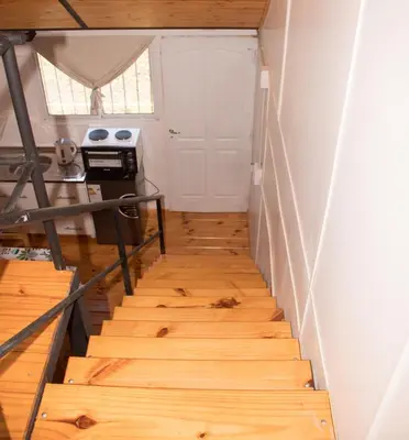 a staircase in a tiny house with wood floors at Cabañas Guayacán in Bialet Massé