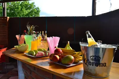 a table topped with plates of fruit and a bottle of beer at Hotel Montana by CPH in Villa Carlos Paz