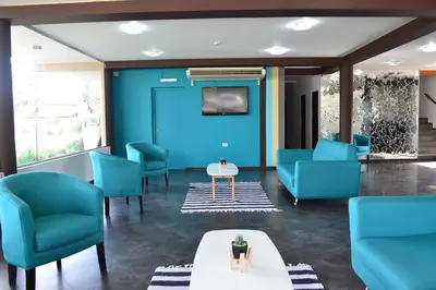 a waiting room with blue chairs and a table at Hotel Montana by CPH in Villa Carlos Paz