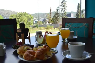 a table with plates of pastries and two glasses of orange juice at Hotel Montana by CPH in Villa Carlos Paz