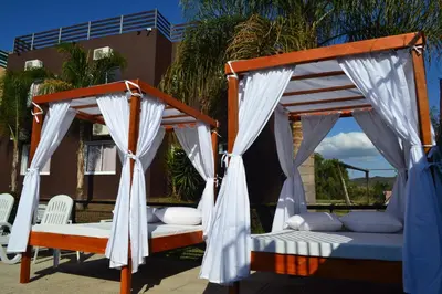 a bedroom with two beds with white curtains at Hotel Montana by CPH in Villa Carlos Paz