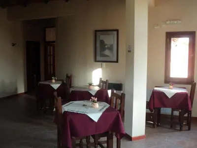 a dining room with two tables with purple table cloth at Hosteria Sueños Dorados in Merlo