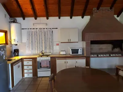 a kitchen with white cabinets and a stove top oven at Hosteria Sueños Dorados in Merlo