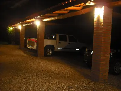 a white truck parked under a garage at night at Hosteria Sueños Dorados in Merlo